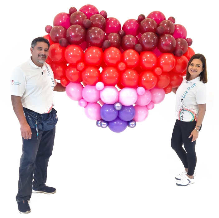 Cursos de decoración con globos | Luz Paz y Omar Bucio sosteniendo un corazón gigante tejido con globos G-link.
