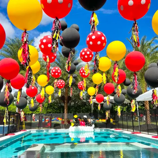 Arco flotante de globos para fiesta en piscina con temática de Mickey Mouse.