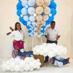 Luz Paz y Omar Bucio posando junto a una impresionante escultura de globo aerostático hecha con globos y técnica orgánica.